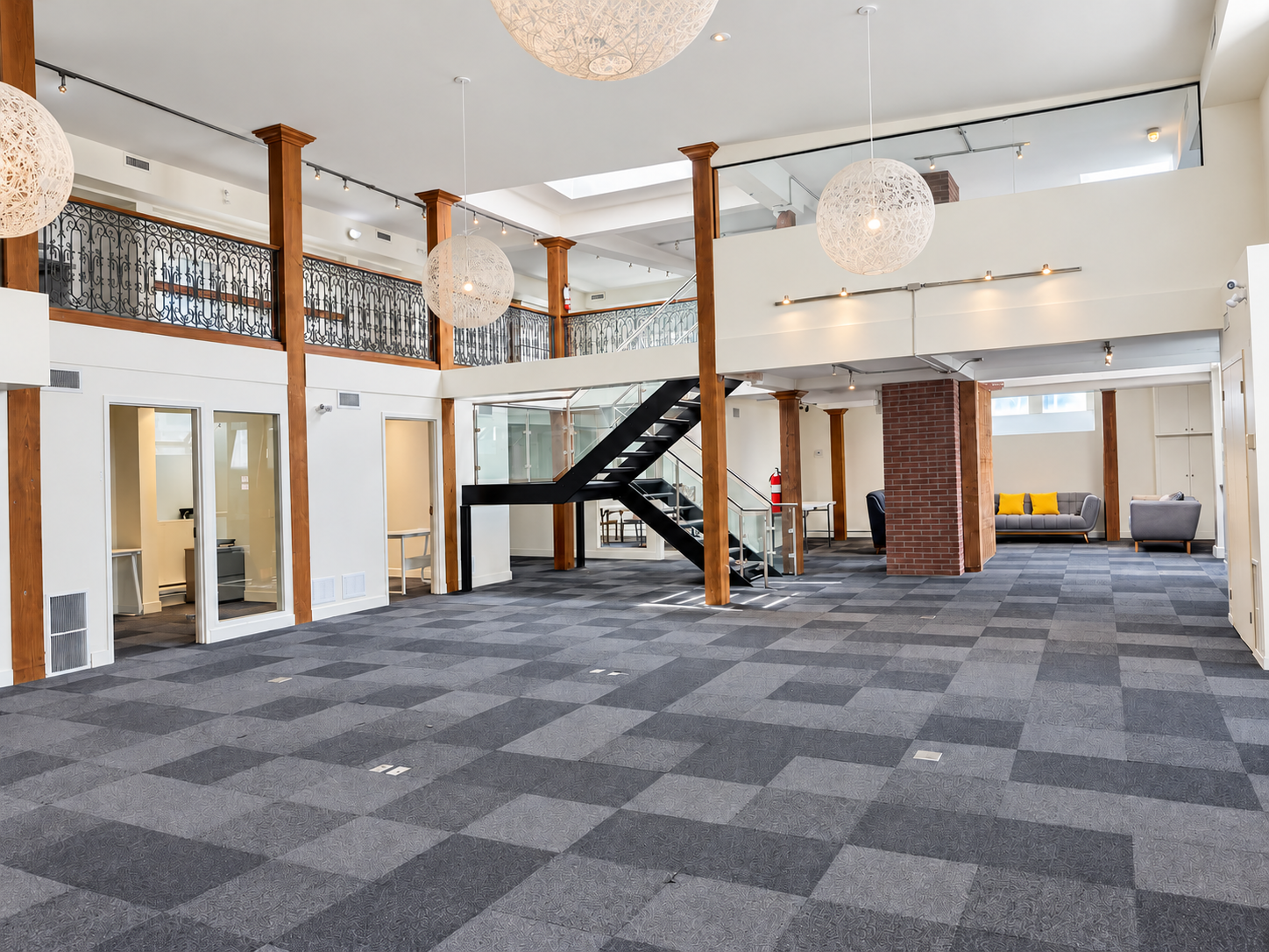 Bright double-height interior with timber columns, a mezzanine and an open floor